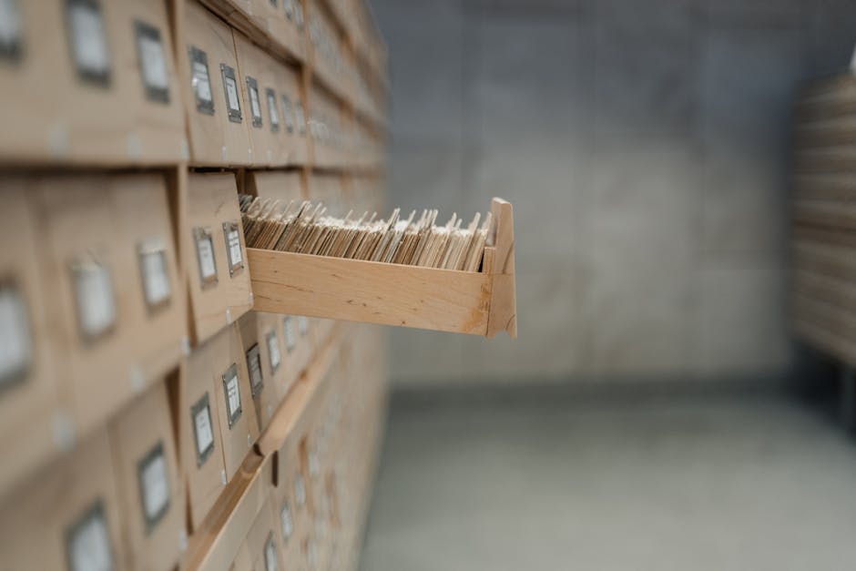 A vintage card catalog drawer in an archive library setting, highlighting organization and history.